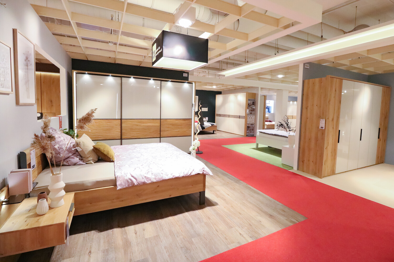 Ausstellungsraum zeigt Bett mit Nachttisch und Kleiderschrank