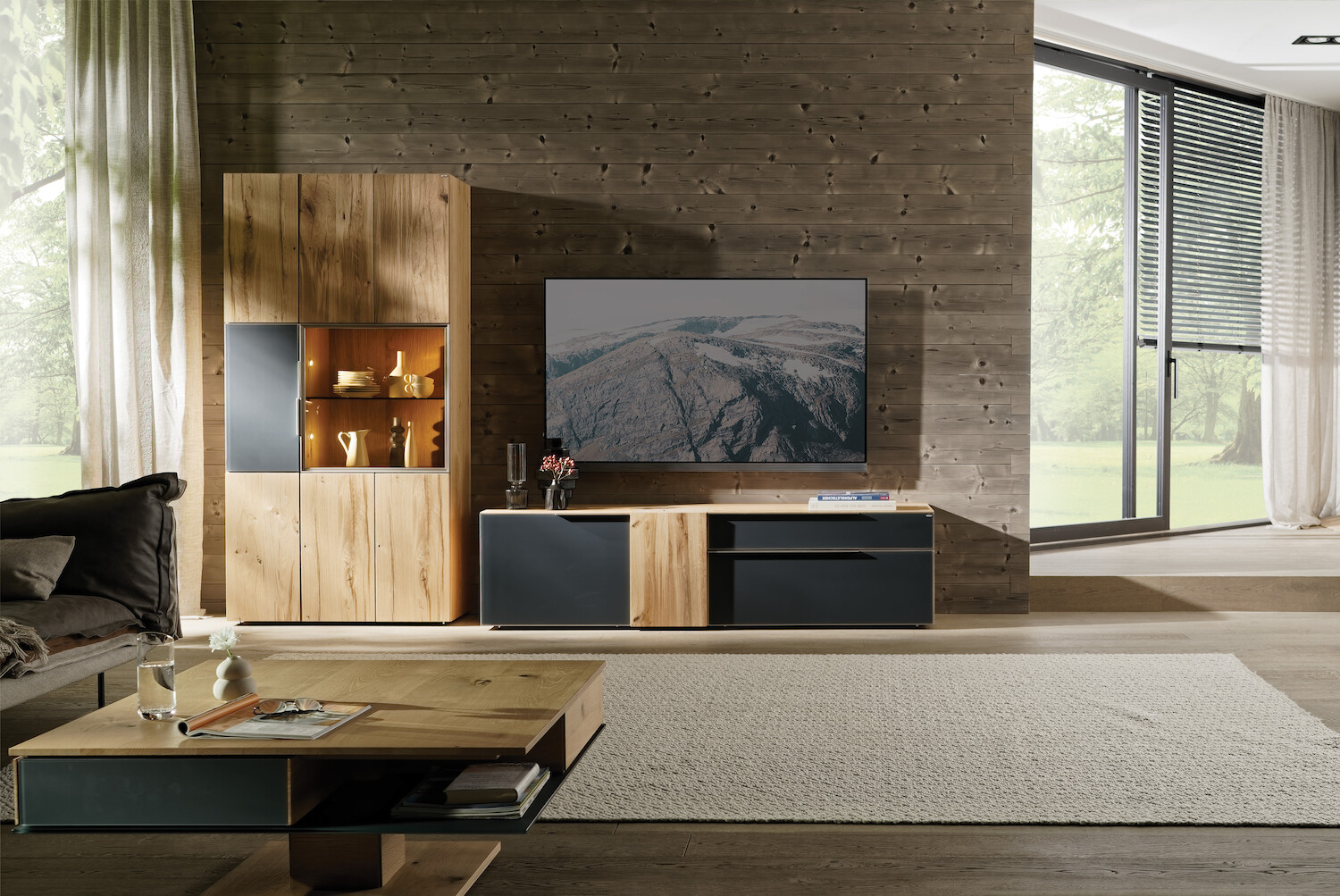 Zu sehen ist eine moderne Wohnwand mit Schrank, TV-Bank und, Couch und Couchtisch.